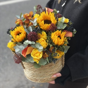 Композиция в сумке "Тональность" из подсолнухов, калл, ягод вибирнума, лимонных роз, скиммии и орхидеи в Солнечногорске